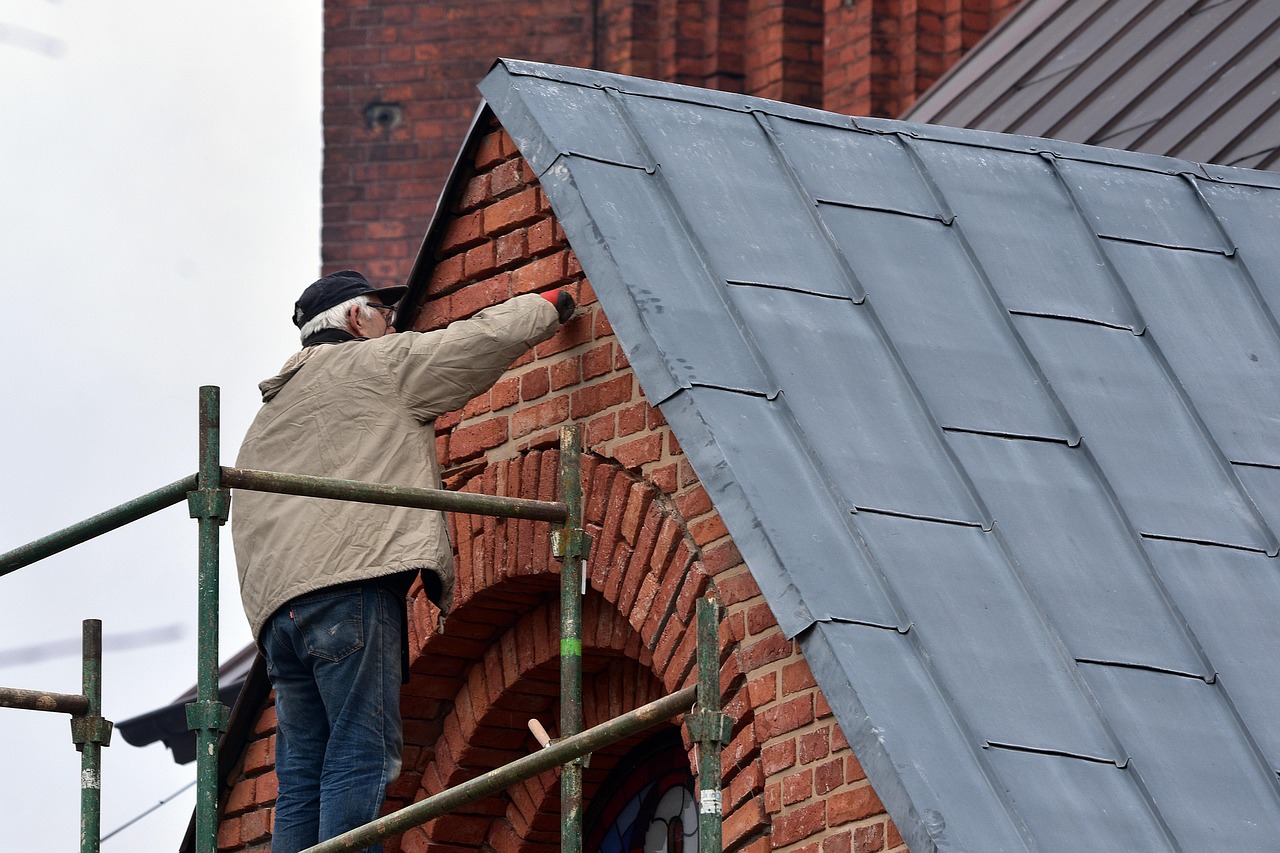 Maler bei der Arbeit – Wand wird mit Spritzpistole renoviert